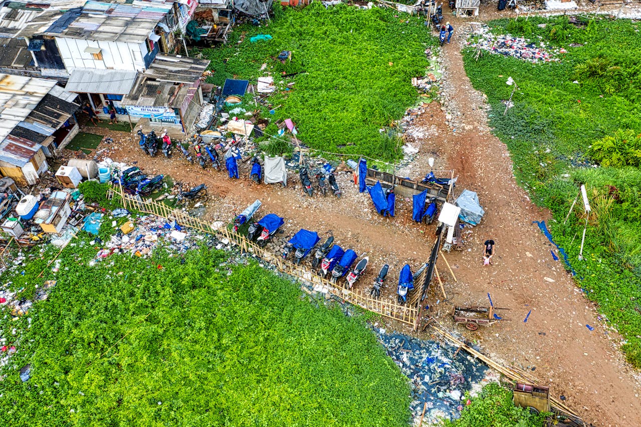 Aerial shot of a slum area in Jakarta, showcasing parked motorbikes and residential structures.